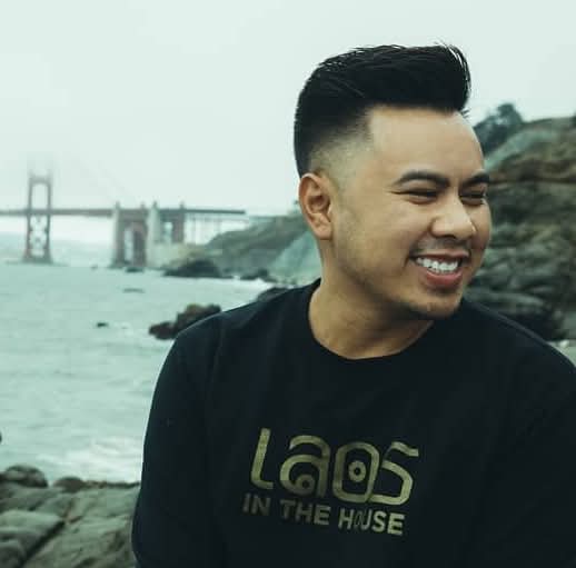Thip, smiling, by the water near the Golden Gate Bridge.